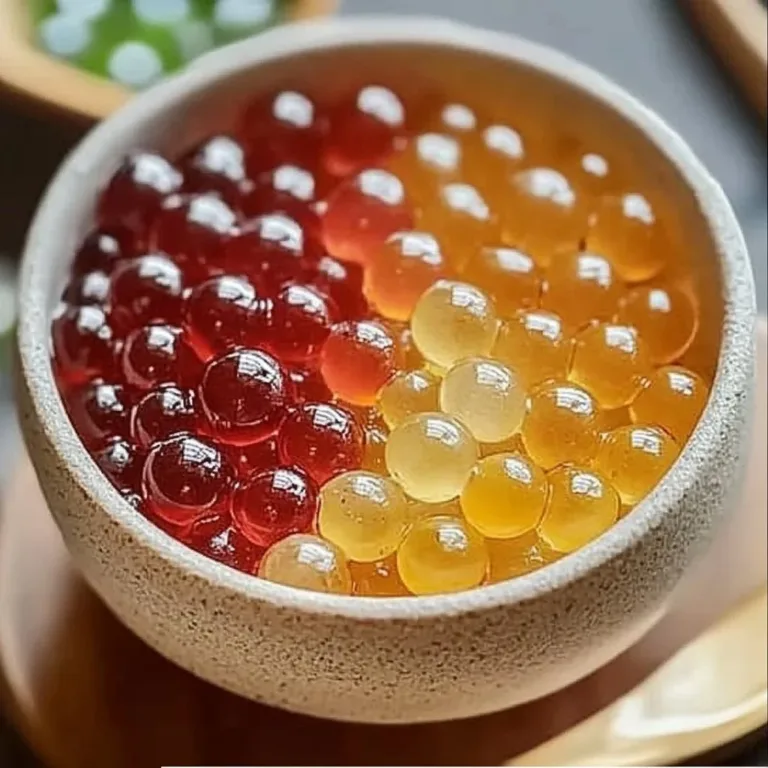 A bowl of colorful homemade popping boba ready for desserts and beverages.